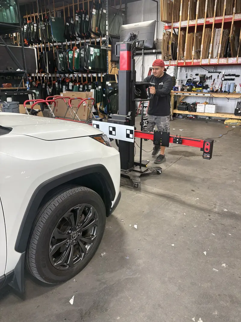 Technician at the ADAS calibration stand with the target bar extended beside a Toyota RAV4 at our Nashville shop