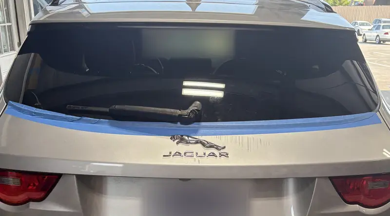 Jaguar F-Pace back glass with blue tape and wiper
