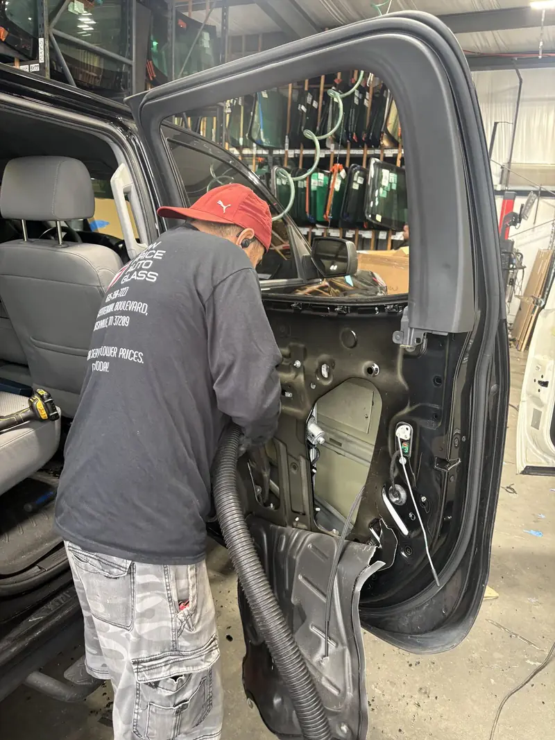 Technician working on wiring inside a door with its panel removed
