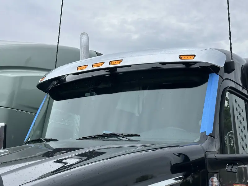 Semi truck windshield with blue tape along the edge