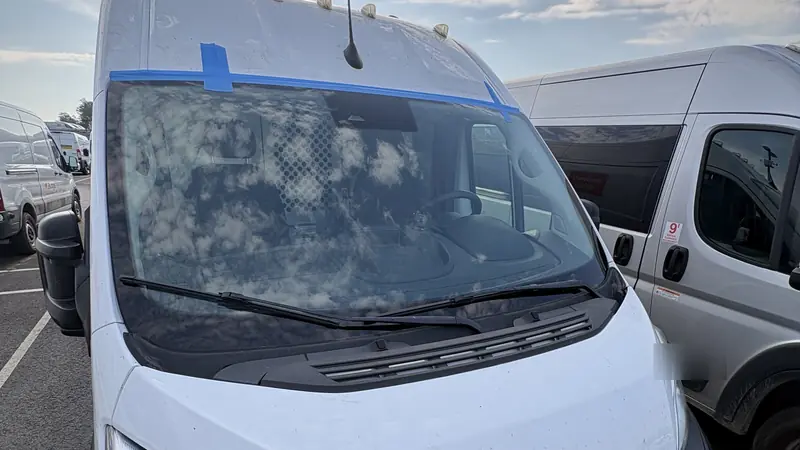 White Ram ProMaster work van with masking tape along its newly installed windshield