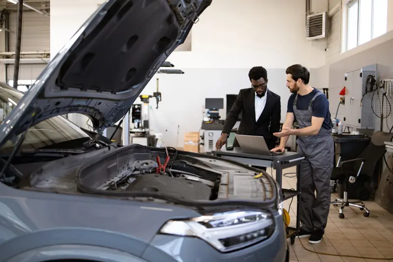 Mechanic and customer reviewing details together on a laptop